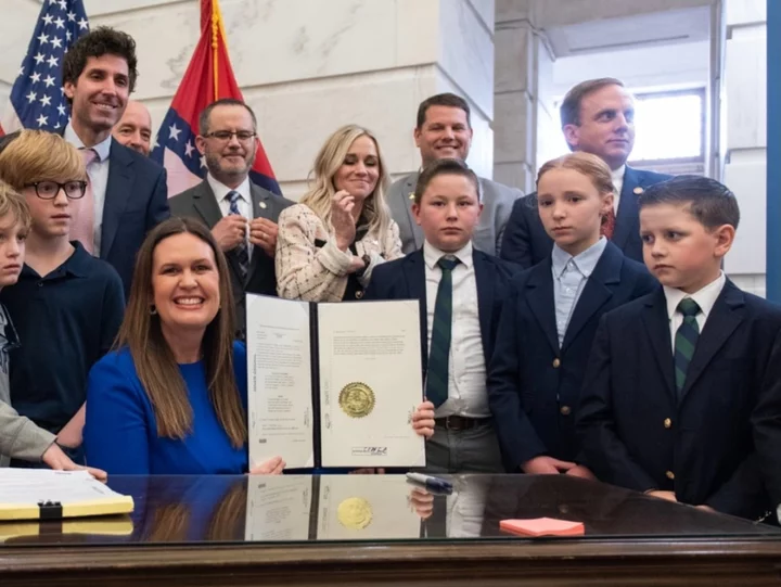 Photo of Sarah Huckabee Sanders beaming next to frowning kids goes viral as child labour laws rolled back